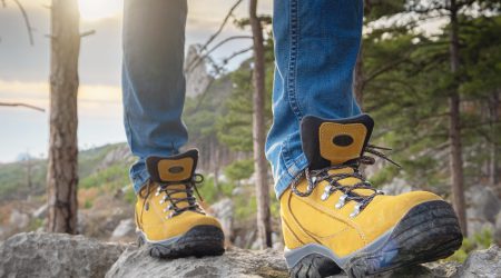 hiking boots close up. female tourist steps on the stone. lifestyle nature concept. Travel hike.
